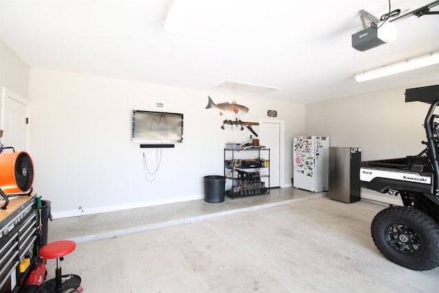 308 Creekside Ln, Lake Jackson, TX 77566 - garage featuring freestanding refrigerator, a garage door opener, and baseboards