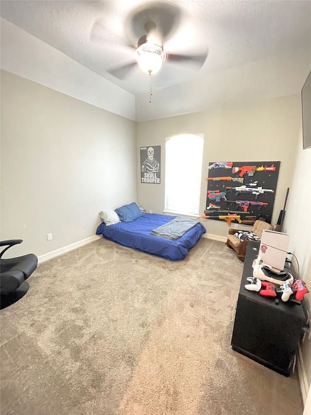 carpeted bedroom featuring ceiling fan and a textured ceiling