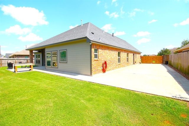 back of house featuring a lawn and a patio area