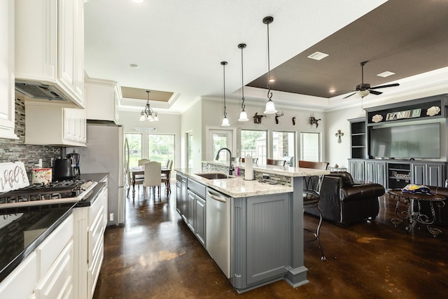 308 Creekside Ln, Lake Jackson, TX 77566 - kitchen with a sink, a tray ceiling, crown molding, stainless steel appliances, and backsplash