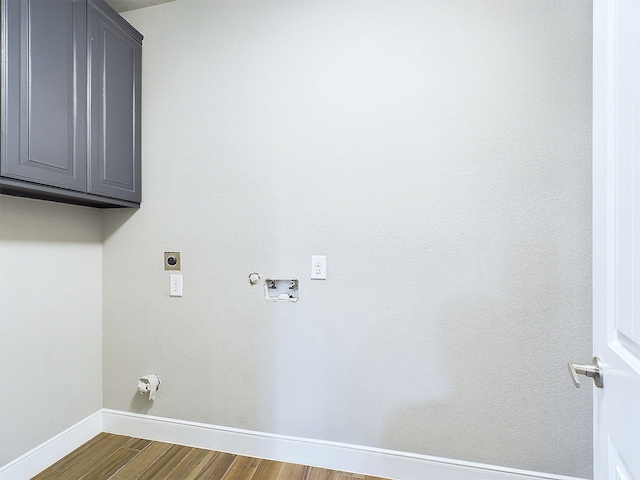 laundry room with cabinets, hookup for an electric dryer, dark wood-type flooring, hookup for a gas dryer, and hookup for a washing machine