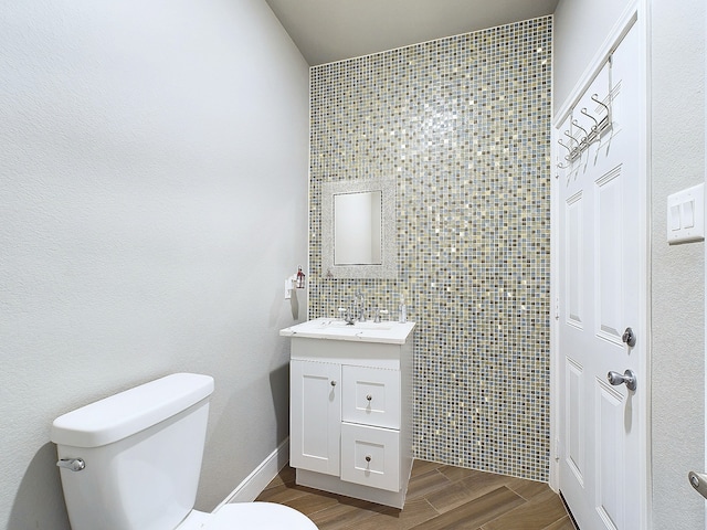 bathroom with tile walls, vanity, toilet, and wood-type flooring