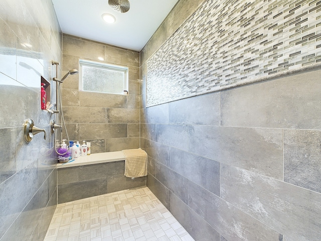 bathroom featuring a tile shower and tile walls