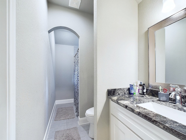 bathroom featuring tile patterned flooring, a shower with curtain, vanity, and toilet