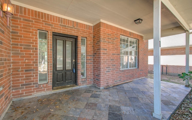 view of exterior entry with a patio