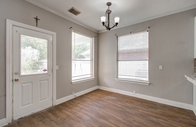 doorway featuring an inviting chandelier, crown molding, and dark wood-type flooring