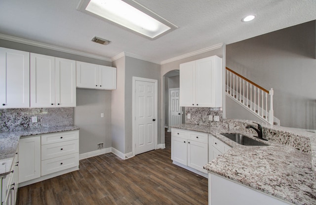 kitchen featuring light stone counters, dark wood-type flooring, sink, and white cabinetry