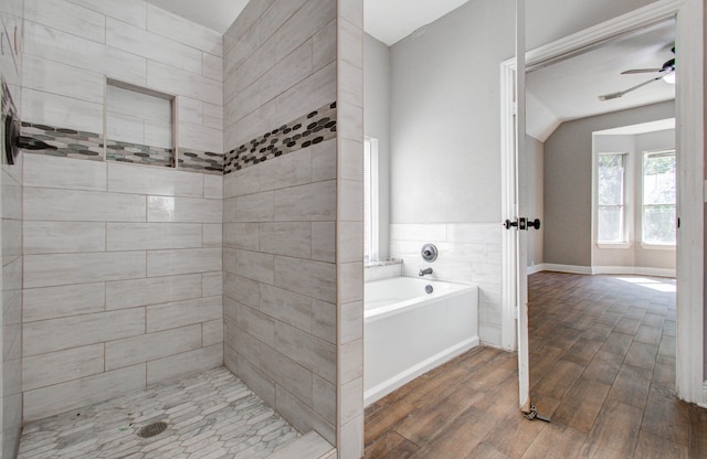 bathroom featuring plus walk in shower, ceiling fan, and hardwood / wood-style floors