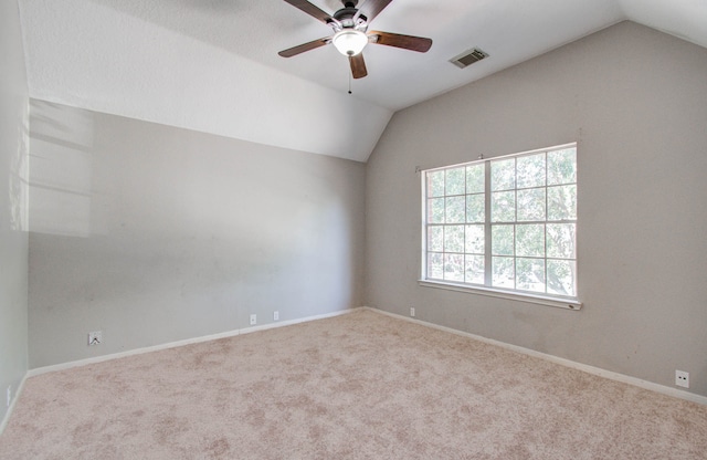 carpeted spare room with vaulted ceiling and ceiling fan