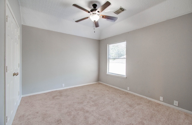 carpeted empty room featuring ceiling fan and a textured ceiling