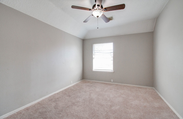 carpeted empty room featuring vaulted ceiling and ceiling fan