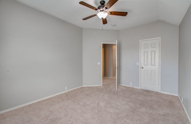 carpeted spare room with ceiling fan and lofted ceiling