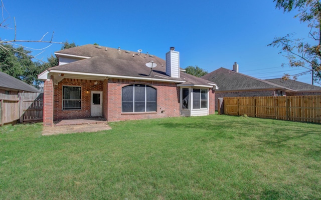 rear view of property with a lawn and a patio