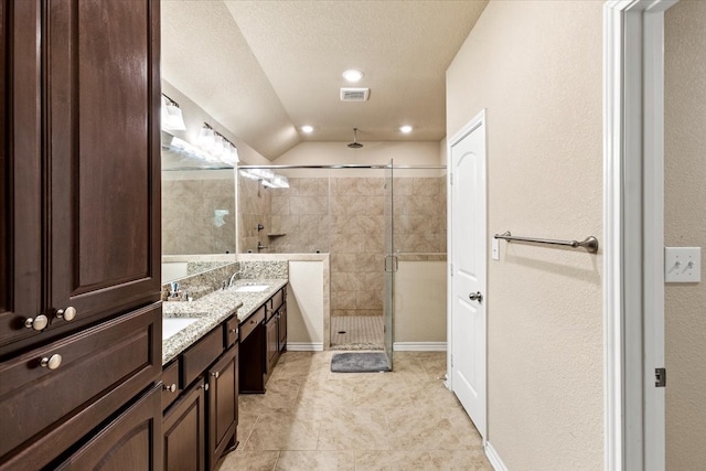 bathroom with tile patterned flooring, a textured ceiling, an enclosed shower, vaulted ceiling, and vanity