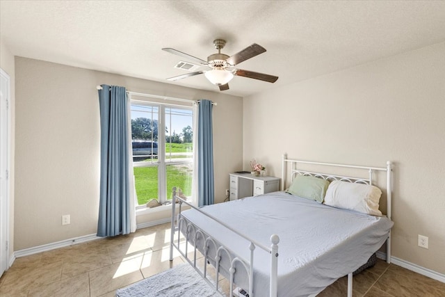 bedroom featuring light tile patterned floors, a textured ceiling, and ceiling fan