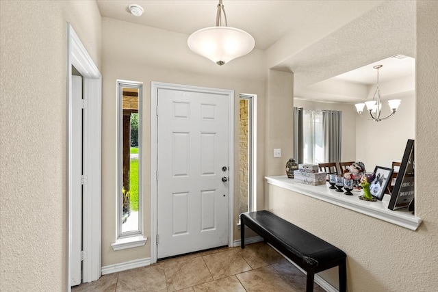 foyer featuring a chandelier and light tile patterned floors