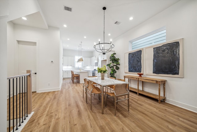 dining room featuring light wood-type flooring and a chandelier