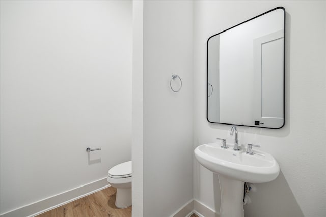 bathroom with hardwood / wood-style flooring and toilet