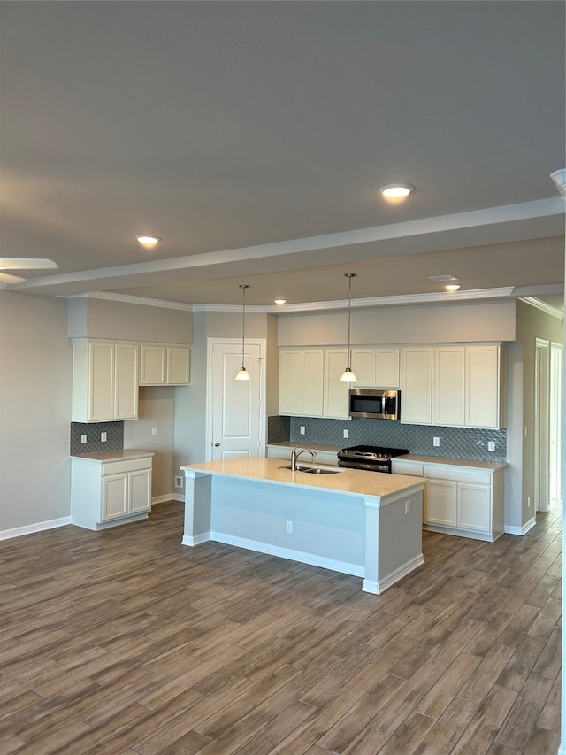 kitchen featuring dark wood-type flooring, an island with sink, white cabinetry, stainless steel appliances, and backsplash