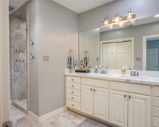 bathroom featuring tile patterned flooring, vanity, and tiled shower