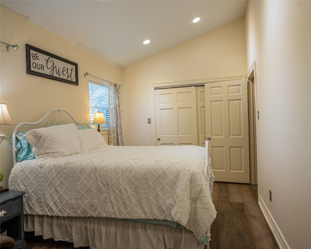 bedroom with a closet, dark hardwood / wood-style flooring, and vaulted ceiling