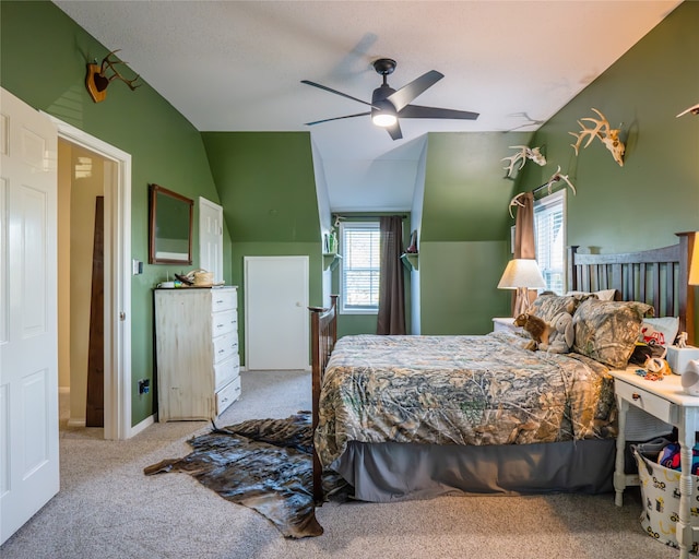 carpeted bedroom featuring ceiling fan and vaulted ceiling