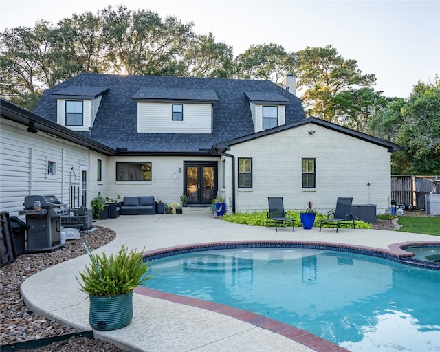 back of property with a patio area, a swimming pool with hot tub, french doors, and an outdoor hangout area