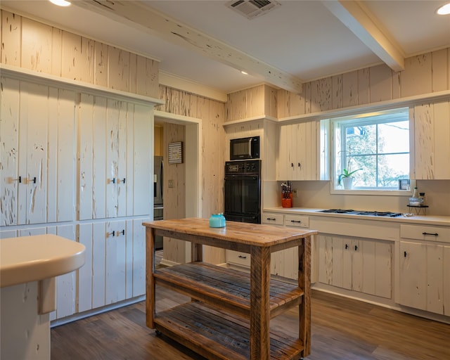 kitchen with beam ceiling, dark hardwood / wood-style flooring, white cabinets, and black appliances