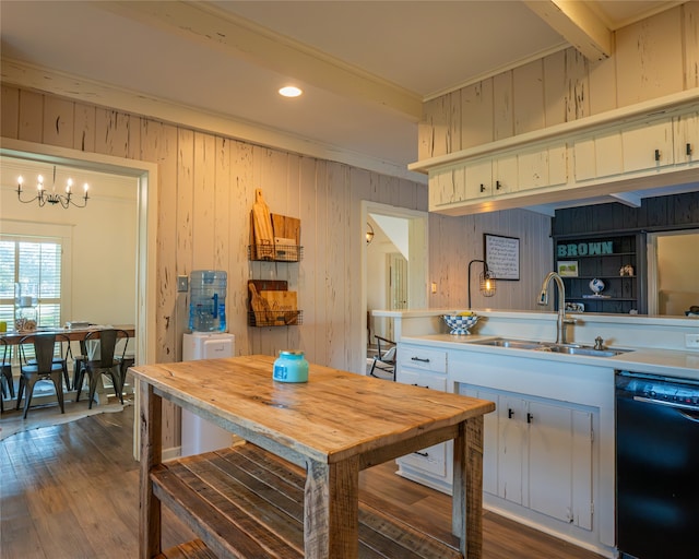 kitchen with dark hardwood / wood-style flooring, white cabinets, wooden walls, sink, and dishwasher