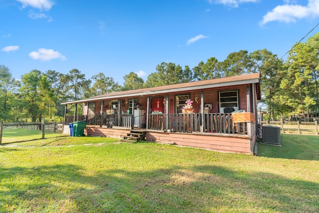 view of front of house with a front yard and central air condition unit