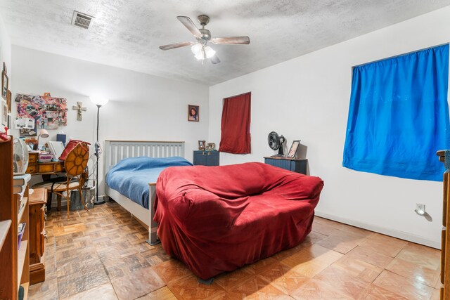 bedroom featuring ceiling fan and a textured ceiling