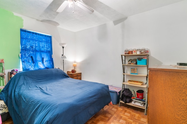 bedroom with parquet flooring, ceiling fan, and a textured ceiling