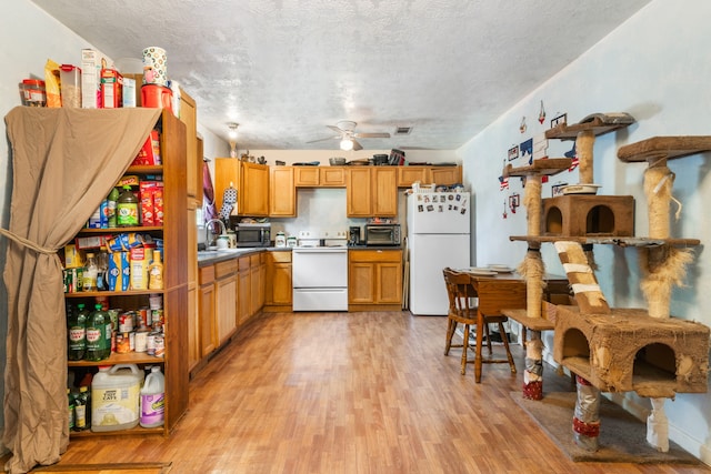 kitchen with ceiling fan, sink, white appliances, a textured ceiling, and light wood-type flooring