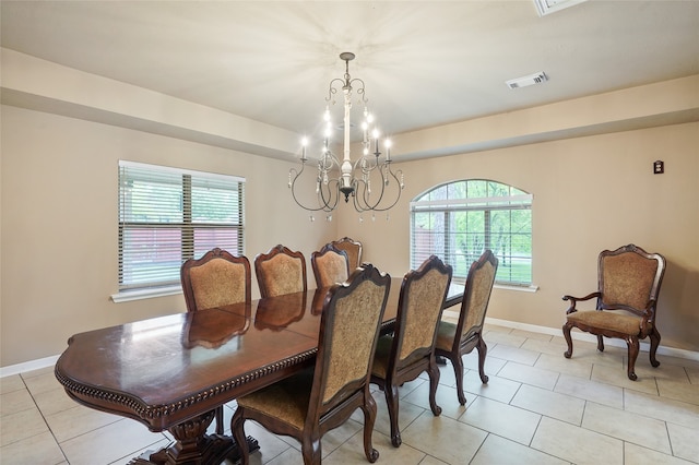 tiled dining space featuring a notable chandelier and a wealth of natural light