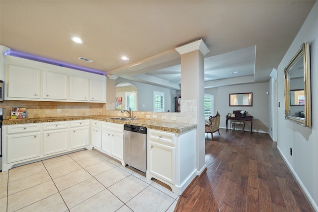 kitchen with white cabinetry, tasteful backsplash, dishwasher, light wood-type flooring, and sink