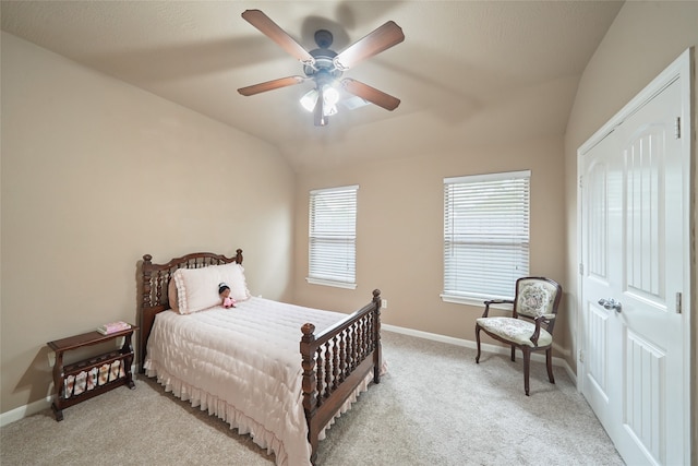 bedroom with ceiling fan, lofted ceiling, and light carpet