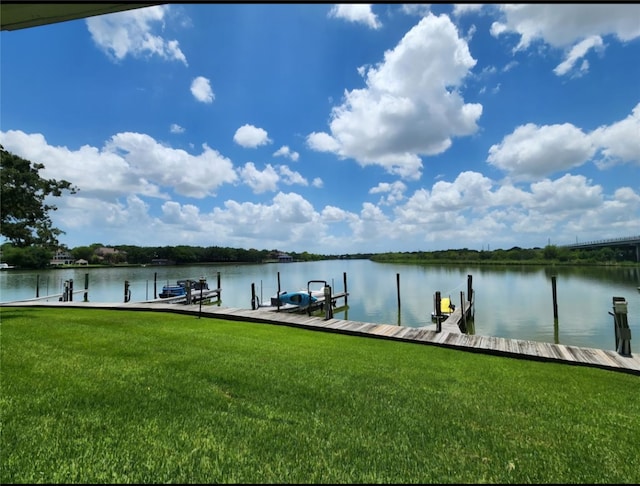 dock area featuring a lawn and a water view