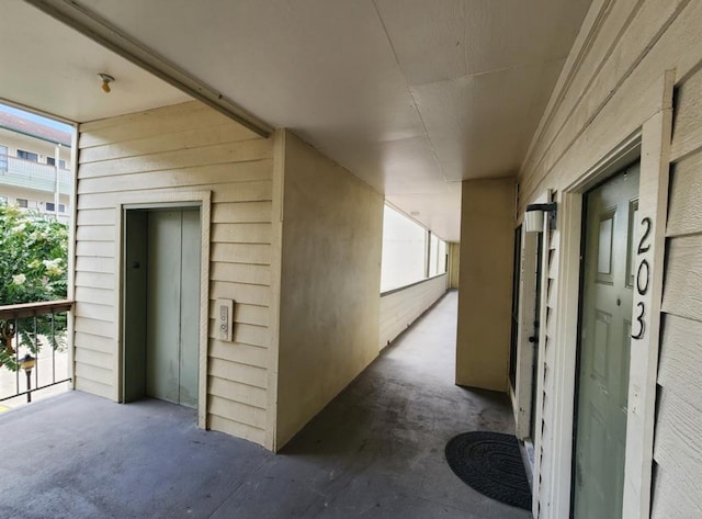 hall featuring concrete flooring and elevator