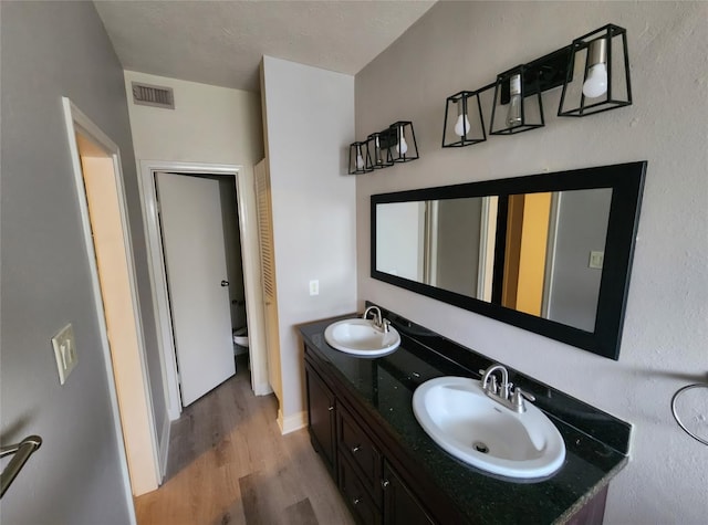 bathroom featuring hardwood / wood-style flooring, vanity, and toilet