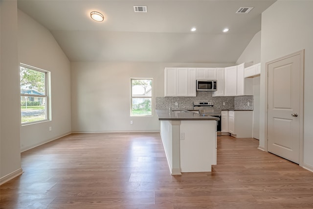 kitchen featuring white cabinets, appliances with stainless steel finishes, high vaulted ceiling, and light hardwood / wood-style flooring