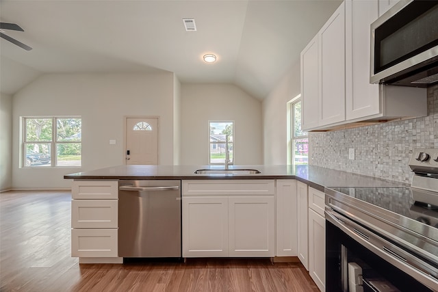 kitchen with ceiling fan, white cabinets, stainless steel appliances, and kitchen peninsula