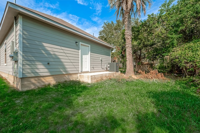 view of side of home featuring a lawn and central air condition unit