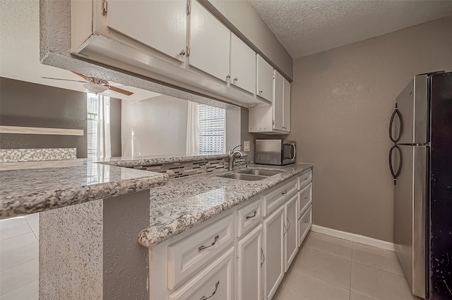 kitchen featuring ceiling fan, white cabinets, sink, kitchen peninsula, and appliances with stainless steel finishes