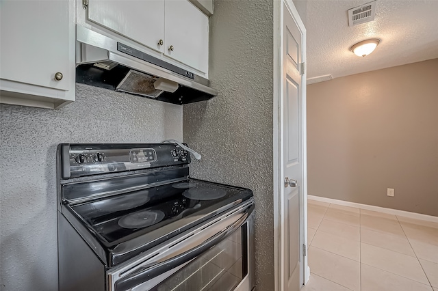 kitchen with white cabinets, black electric range, a textured ceiling, and light tile patterned flooring