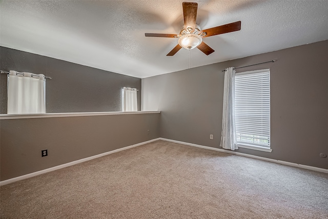 carpeted empty room with ceiling fan and a textured ceiling