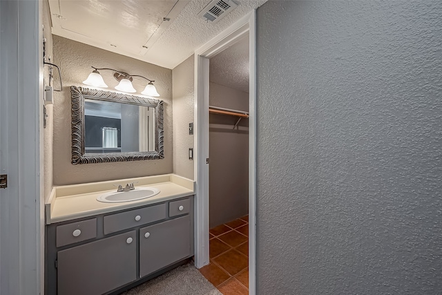 bathroom featuring tile patterned flooring, a textured ceiling, and vanity