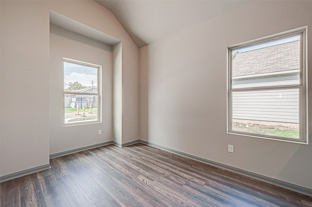 unfurnished room featuring vaulted ceiling and dark wood-type flooring