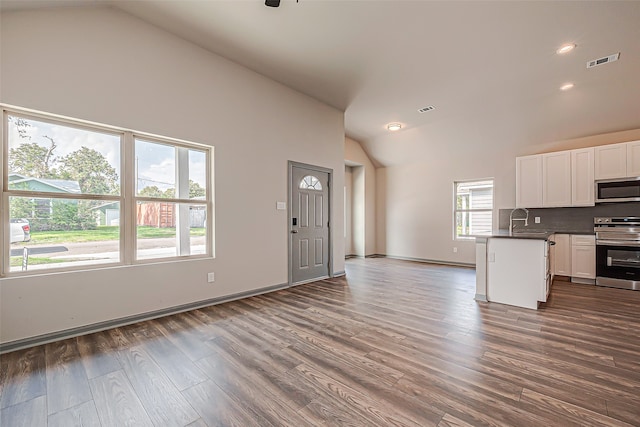 kitchen featuring dark wood-type flooring, sink, white cabinetry, decorative backsplash, and appliances with stainless steel finishes