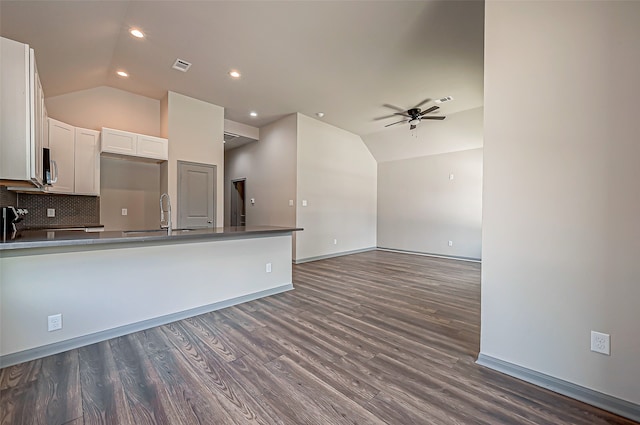 kitchen with white cabinets, vaulted ceiling, ceiling fan, and dark wood-type flooring