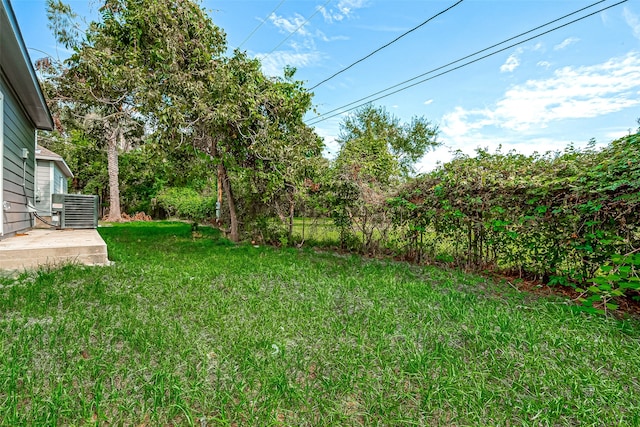 view of yard with cooling unit and a patio